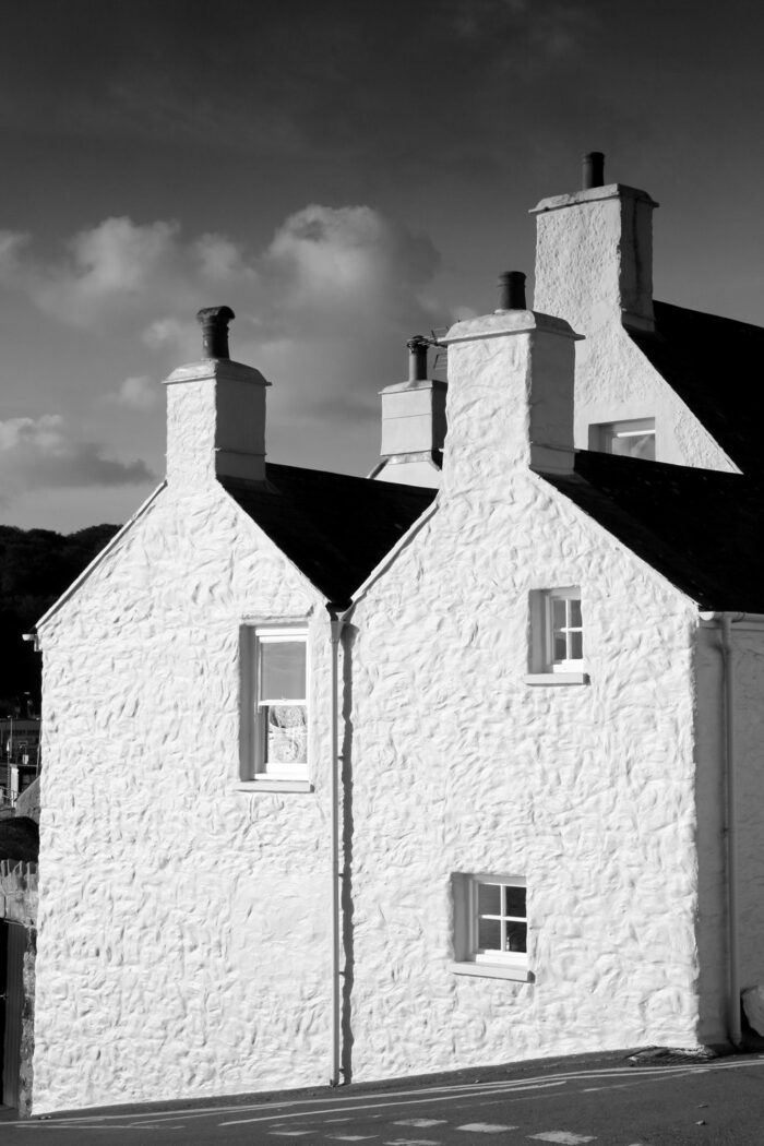 A landscape photograph of three white pine-ends in the village of Dale in Pembrokeshire in Wales