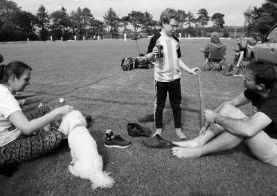 A family watch a village cricket match